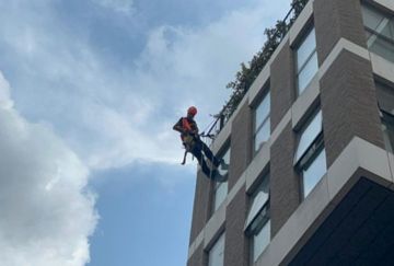 Avisan Rope access technician abseiling performing high level window cleaning