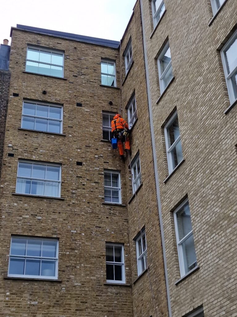 Avisan rope access technician working on building