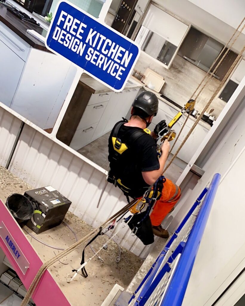 Avisan Rope access technician working on banner signage installation