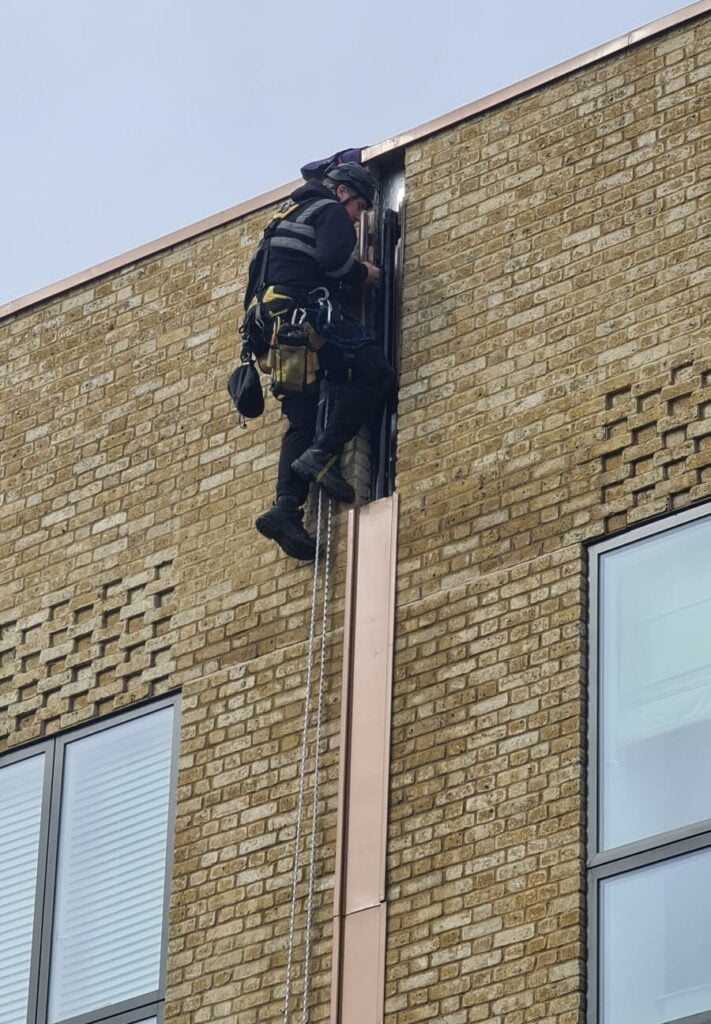 Avisan rope access technician working on building surveying for damp remedial repairs and maintenance