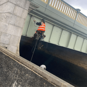 Man from rope access company hanging from Rochester Bridge