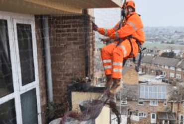 Avisan rope access technician using safe rope access to clean residential building